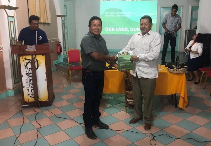 Toshao and Chairman of the Upper Mazaruni District Council Mario Hasting  (at left) presenting the report to Indigenous Peoples’ Affairs Minister Sydney Allicock yesterday. 