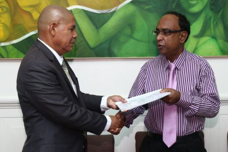 Guyana Amazon Warriors Operations Manager, Omar Khan (right) and Minister of Social Cohesion Dr. George Norton shake hands on reaching the agreement. 
