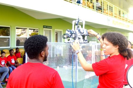Jara Emtage-Cave of Barbados (right) and Daniel Baldeo-Thorne of Guyana getting ready to place their under-water robot into the tank during the SPISE 2019 Final Projects Presentations. (CSF photo)