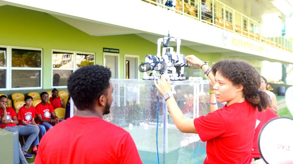 Jara Emtage-Cave of Barbados (right) and Daniel Baldeo-Thorne of Guyana getting ready to place their under-water robot into the tank during the SPISE 2019 Final Projects Presentations. (CSF photo)