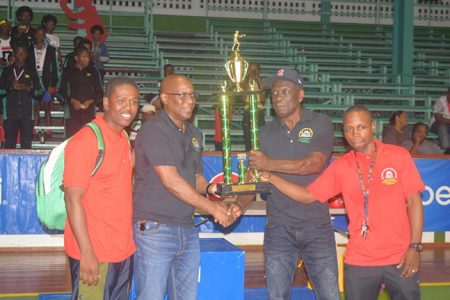 Coaches Lennox Daniels, Sebert Blake (right) and Clive Atwell (left) receive the the Champion Country trophy from GBA president Steve Ninvalle.