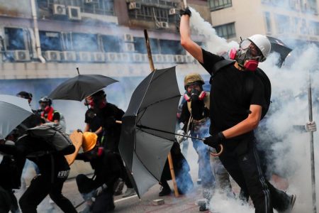 A demonstrator throws back a tear gas canister as they clash with riot police during a protest in Hong Kong, China, August 24, 2019. REUTERS/Tyrone Siu