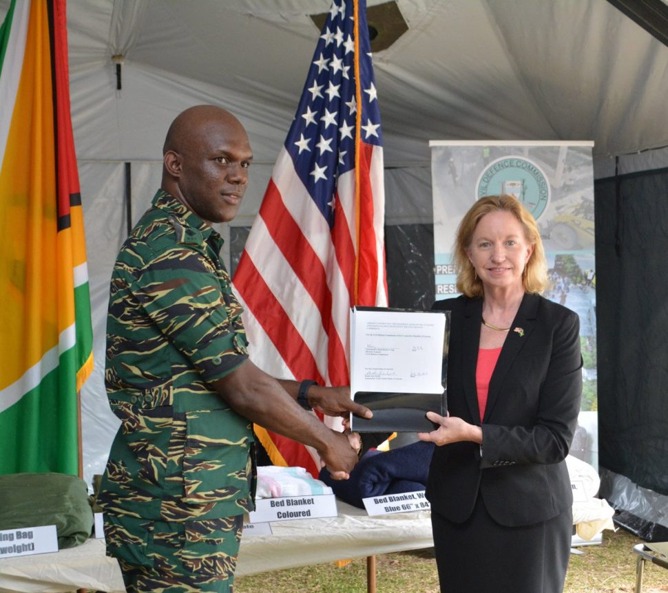 Director General of the Civil Defence Commission (CDC) Lieutenant Colonel Kester Craig receives a certificate documenting the items donated by the United States Department of Defense Humanitarian Assistance Program from US Ambassador to Guyana,  Sarah-Ann Lynch. (Ministry of the Presidency photo)


