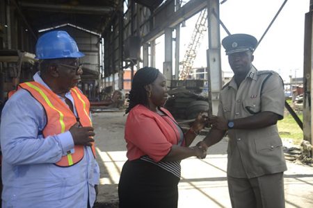 Permanent Secretary of the Ministry of Public Security Daneilla McCalmon (centre) handing over the keys to the boat to Director of Prisons (ag) Gladwin Samuels. (Depart-ment of Public Information photo)