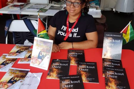 Gabrielle Mohamed displaying her two books at CARIFESTA