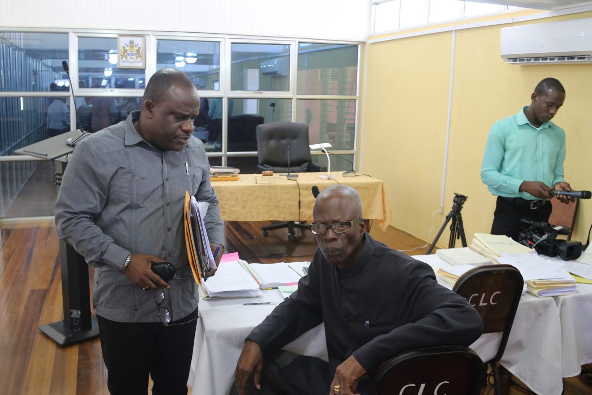Royston King (left) consulting with his lawyer, Maxwell Edwards, during an adjournment of a CoI hearing last October. (Stabroek News file photo) 