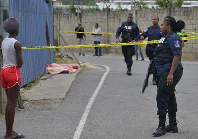 FLASHBACK: A resident of Pioneer Drive, Sea Lots, watches the body of Ronald Joseph who was murdered.
