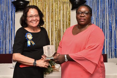 First Lady Sandra Granger (at left) receives a token of appreciation from Chief Librarian Emily King at the National Library’s Staff Appreciation Ceremony on Friday. (Ministry of the Presidency photo)
