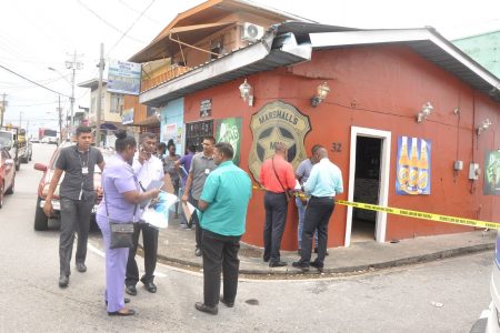 Police investgators at the scene of the shooting at Marshall’s Korner at the corner of Sutton and Cipero Streets, San Fernando, yesterday.