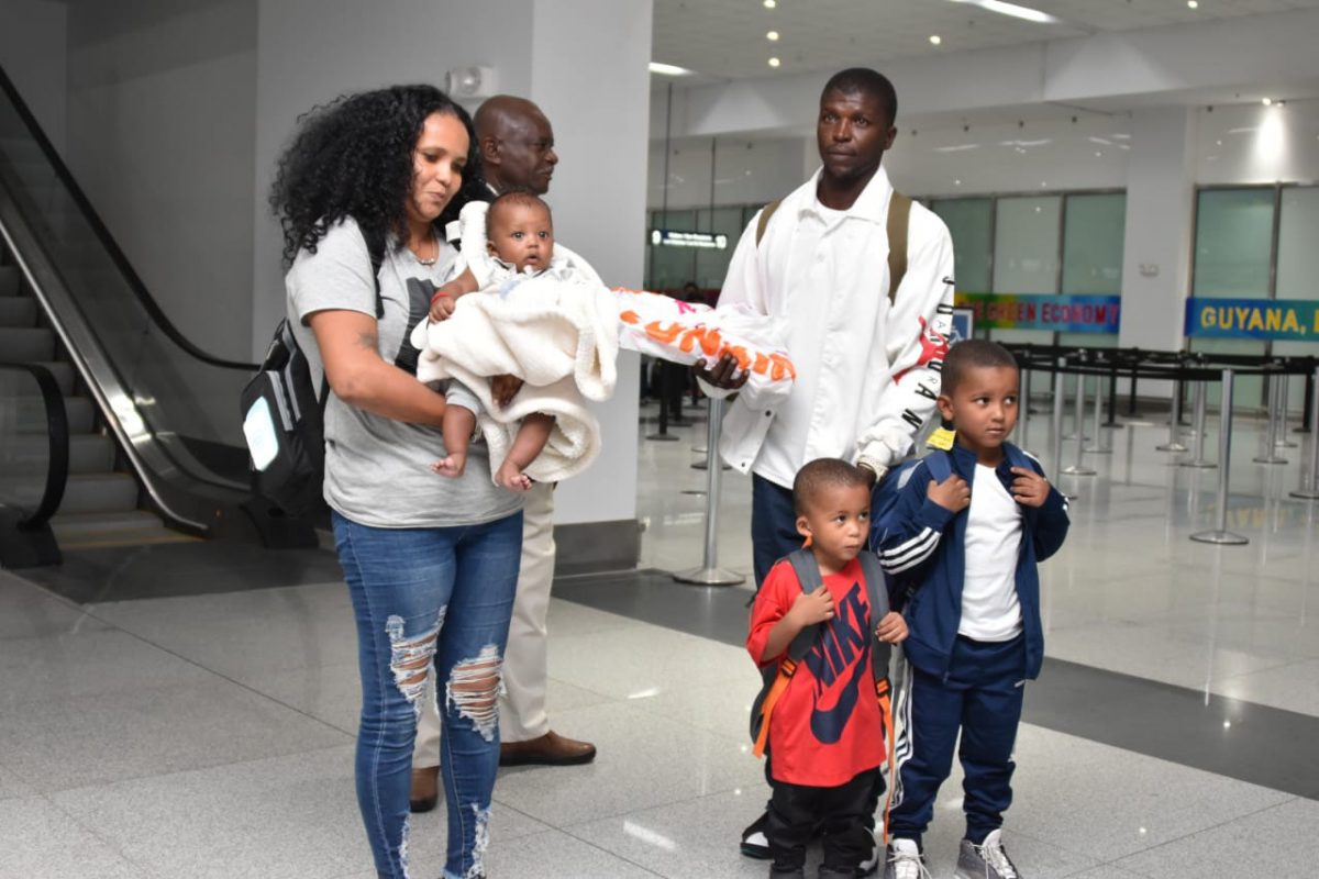 Stevie Cooper, his wife Vanessa Tate and their three children, with Minister of Citizenship, Winston Felix (second left), moments after arriving in Guyana from The Bahamas. (Ministry of the Presidency photo)