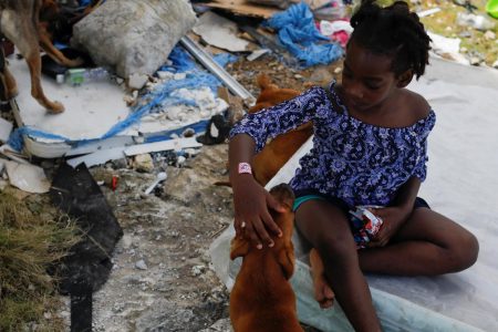 A girl pets her dog after Hurricane Dorian hit the Abaco Islands in Spring City, Bahamas, September 11, 2019. REUTERS/Marco Bello
