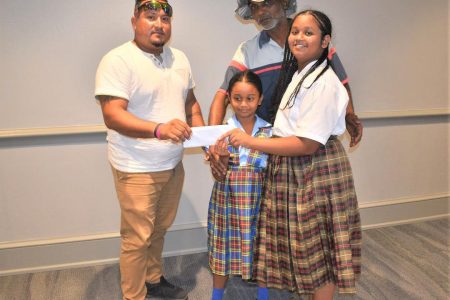 Guyana Amazon Warriors Media Officer John Ramsingh (left) makes the donation on behalf of the team to Shaniece Nahoe’s father and siblings while in St. Kitts & Nevis.
