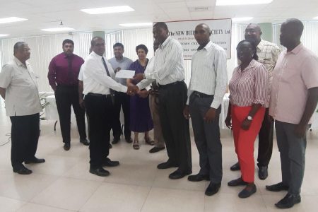 NBS Chief Executive Officer, Anil Kishun presents GCA President, Roger Harper with the sponsorship cheque in the presence of the company’s directors and members of the GCA
