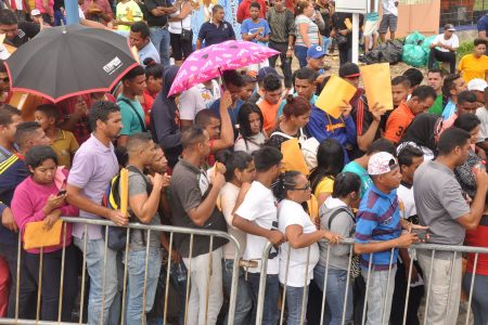Flashback: Venezuelan nationals wait to register outside the Achievors Banquet Hall, Duncan Village, San Fernando, in June.