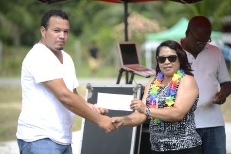 Minister of State, Dawn Hastings-Williams (right) handing over the land permit to President of the Speightland Logging and Agriculture Cooperative, Kevon Lorrmier. (DPI photo)