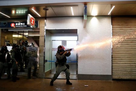 A riot police officer fires a tear gas canister during a rally in Central, Hong Kong, China September 8, 2019. REUTERS/Kai Pfaffenbach