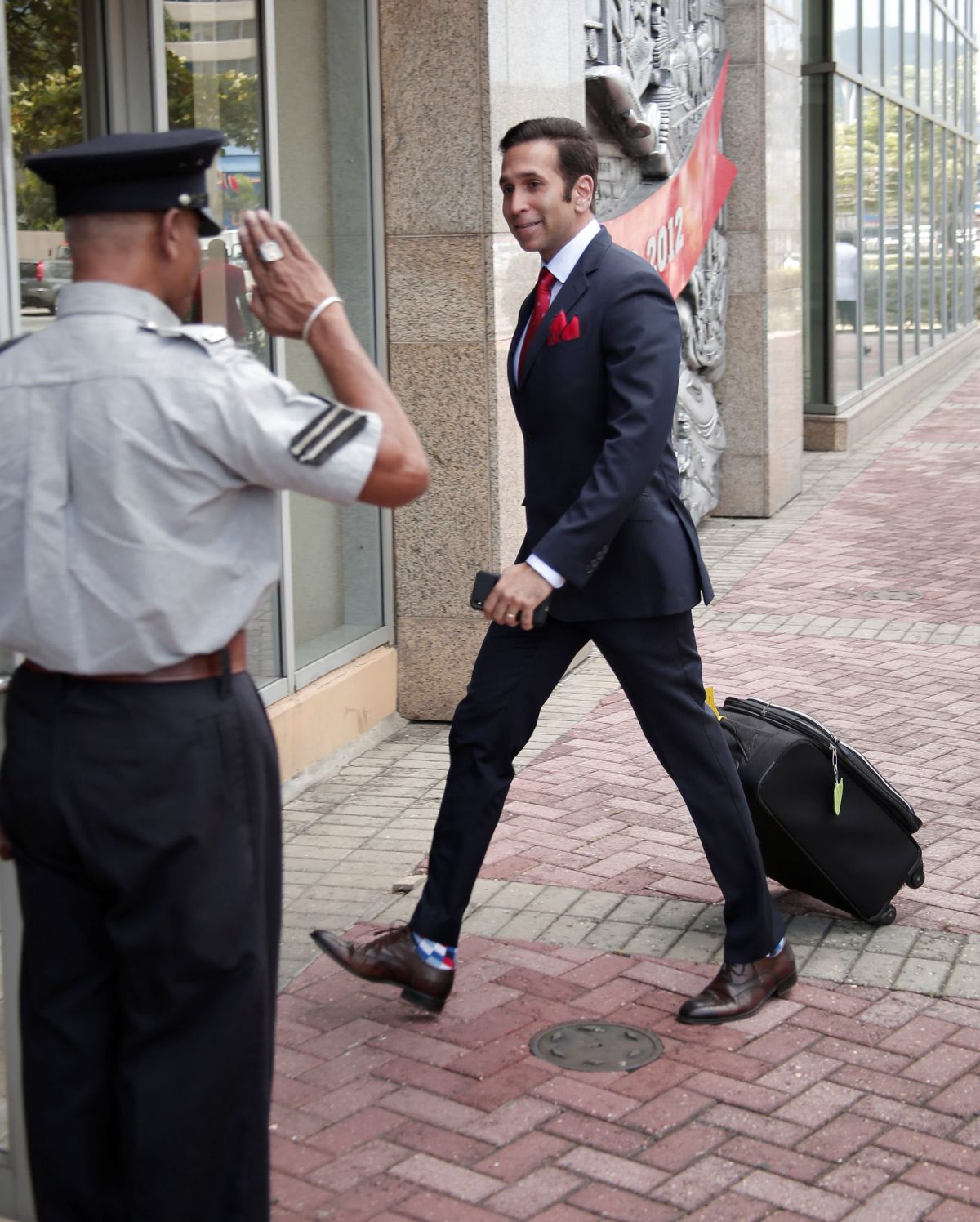 Attorney General Faris Al-Rawi is saluted by a police officer on his arrival to Parliament, yesterday.