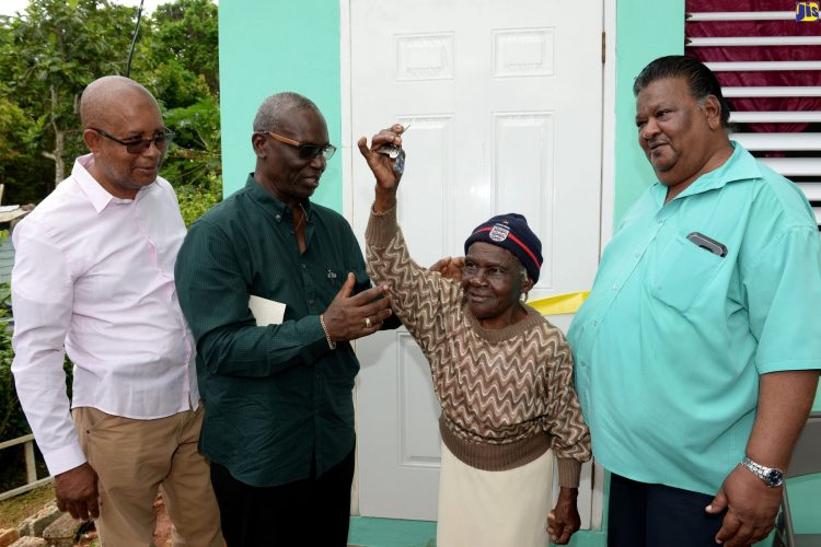 Ninety-five year old Nora Johnson (second right), proudly displays the key to her new home which was handed over to her by Local Government and Community Development Minister Desmond McKenzie (second left), during a ceremony in Mendez District, Point Hill, St. Catherine on Monday (October 7). Looking on (from left) are Mayor of Spanish Town, Councillor Norman Scott; and Councillor for the Point Hill Division, Wesley Suckoo. (Photo: JIS)