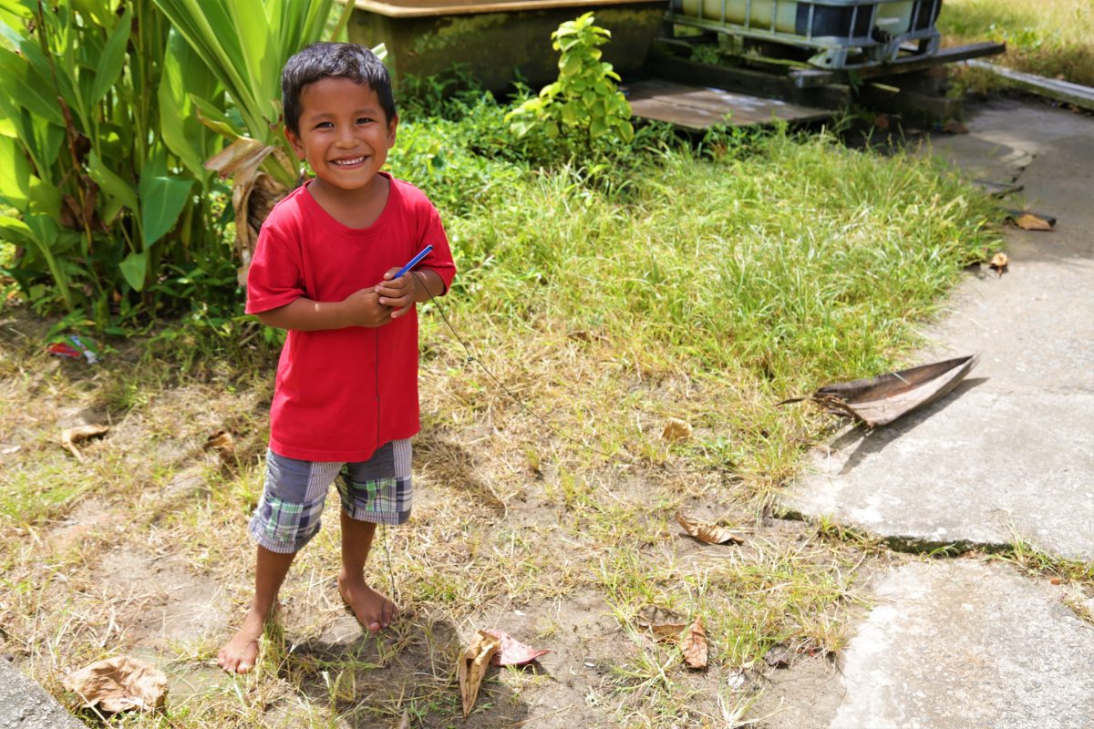 Six-year-old Blake Primary School student Mario Williams pulling his tree-branch boat around his yard
