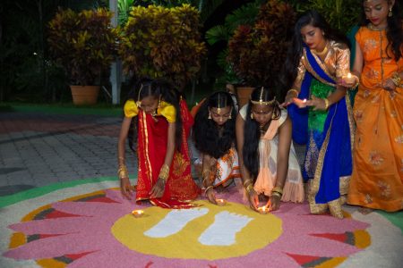 Invitees placing lit diyas into the Rangoli design yesterday at the Baridi Benab, State House, where Prime Minister Moses Nagamootoo, his wife, Mrs. Sita Nagamootoo as well as Speaker of the National Assembly, Dr. Barton Scotland, Members of Parliament, Members of the Diplomatic Corps and special invitees joined the Hindu community in observing Diwali. (Department of Public Information photo) 
