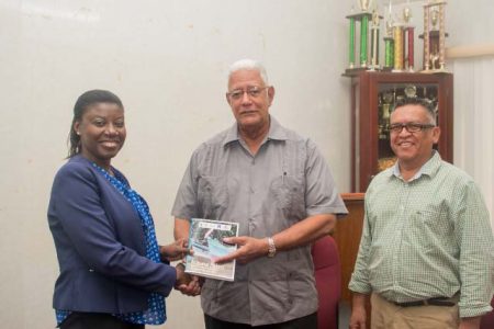 From left:  Country Manager of WWF Guianas, Aiesha Williams hands over the Artisanal Fishery Management Plan to Minister of Agriculture, Noel Holder and Chief Fisheries Officer within the Department of Fisheries, Denzil Roberts. (DPI photo)