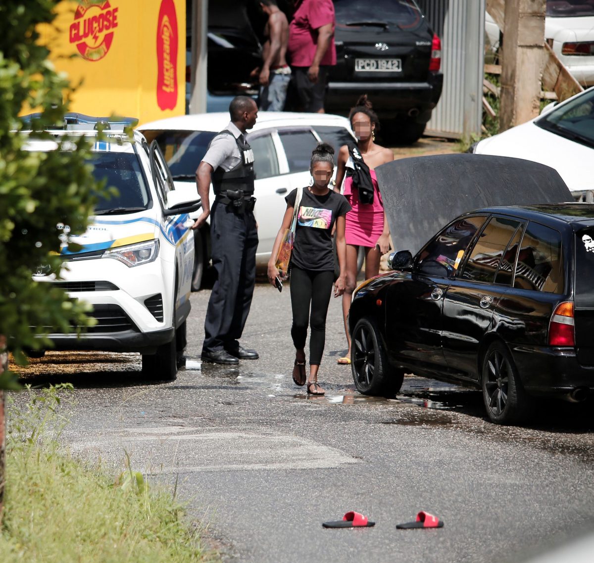 A police officer warns residents to avoid contaminating the crime scene following the murder of Shaquille Holder (inset) at Belle Vue Road, Long Circular, yesterday.