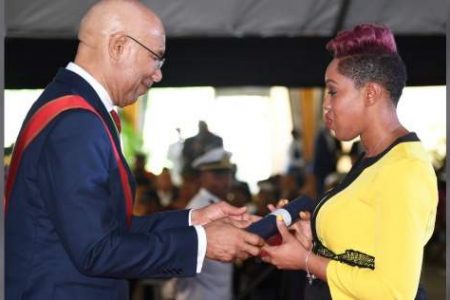 Petronia McLeish Bennett, widow of Jamaica Defence Force Lance Corporal Ricardo Bennett, receives the Medal of Honour for Gallantry from Governor General Sir Patrick Allen at King's House in St Andrew, yesterday on behalf of the soldier who was being honoured posthumously for his quick, daring and selfless actions in challenging gunmen who attempted to rob a beauty and barber salon in Cross Roads, Kingston, with no apparent regard for his own safety, resulting in his death. (Photo: Joseph Wellington)