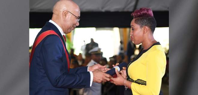 Petronia McLeish Bennett, widow of Jamaica Defence Force Lance Corporal Ricardo Bennett, receives the Medal of Honour for Gallantry from Governor General Sir Patrick Allen at King's House in St Andrew, yesterday on behalf of the soldier who was being honoured posthumously for his quick, daring and selfless actions in challenging gunmen who attempted to rob a beauty and barber salon in Cross Roads, Kingston, with no apparent regard for his own safety, resulting in his death. (Photo: Joseph Wellington)