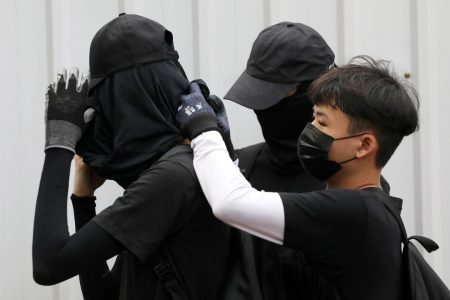 FILE PHOTO: Anti-government protesters adjust their masks during a protest at Wong Tai Sin district, in Hong Kong, China, October 13, 2019. REUTERS/Athit Perawongmetha/File Photo
