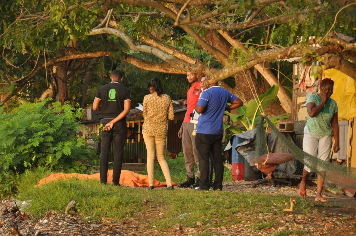 Crime Scene Investigators, CSI, and Embacadere residents look at the body Neville Boland who drowned while swimming at Black Stone, San Fernando yesterday.