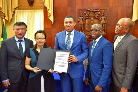 Prime Minister, Andrew Holness (centre); and President of China Harbour Engineering Company Limited’s (CHEC) Americas Division, Dr Zhimin Hu (second from left), display the signed agreement for the $9.5-billion Catherine Estates housing development in St Catherine, during a ceremony at Jamaica House yesterday. (Photo: JIS)