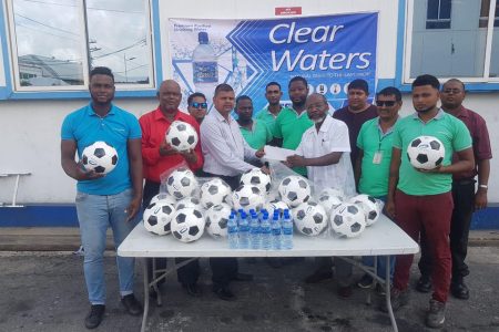 Clear Waters Managing Director Ricky Looknauth (fourth left) handing over the balls to coordinator Lennox Arthur in the presence of staffers.