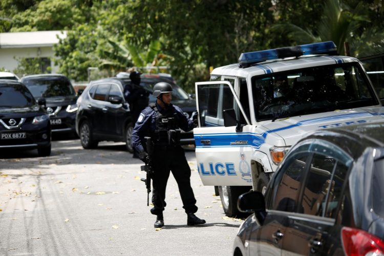 A police officer walks along the road in Malabar outside of the house where a mother and daughter were held hostage yesterday.