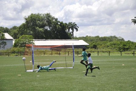 Jaheam Lewis [right/white] recording the second goal against Timehri Panthers to seal his side’s berth in the final of the (EBFA)/Ralph Green Under-11 Football Championship at the National Training Centre, Providence.