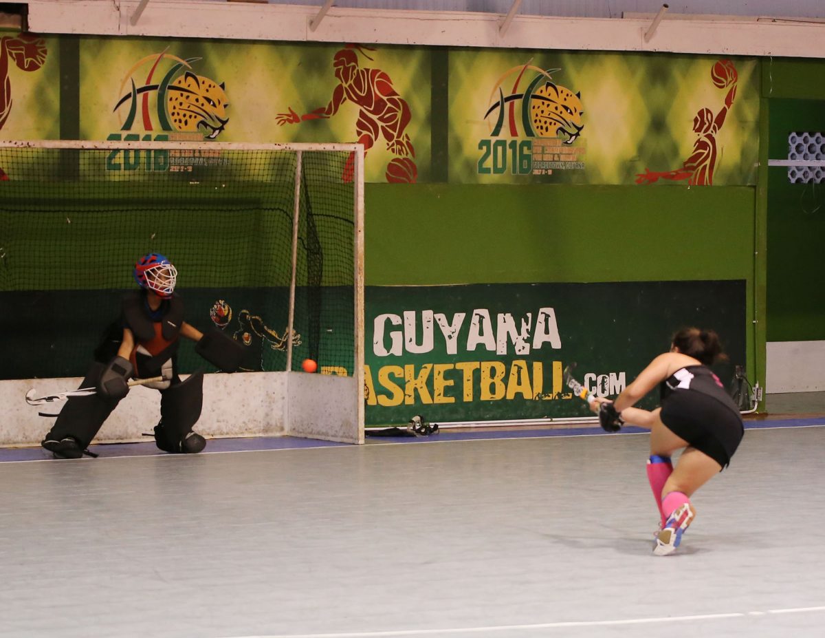 Marzana Fiedtkou of GBTI GCC Tigers in the process of scoring from the penalty spot against Saints in the Women’s Division of the GTT National Indoor Hockey Championship at the Cliff Anderson Sports Hall, Homestretch Avenue
