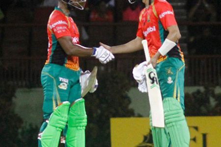 Mission Accomplished! Nicholas Pooran (left) and Shoaib Malik shake hands after Guyana Amazon Warriors defeated Trinbago Knight Riders by seven wickets (Orlando Charles photo)
