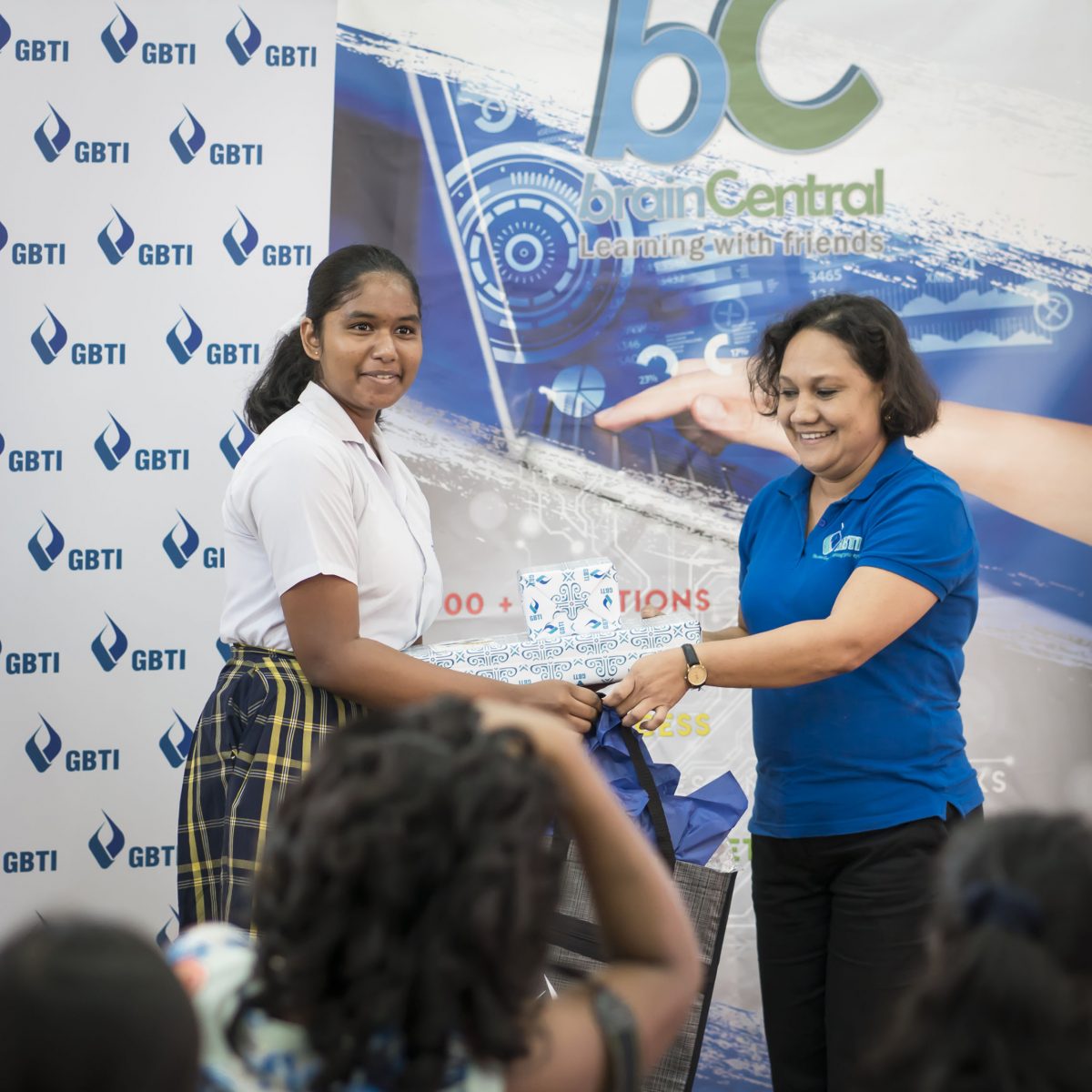 (Left) Renika Anand receiving her prizes from GBTI’s Marketing & Communications Officer, Nadia De Abreu.