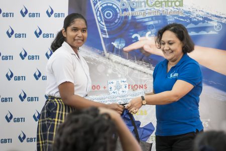 (Left) Renika Anand receiving her prizes from GBTI’s Marketing & Communications Officer, Nadia De Abreu.