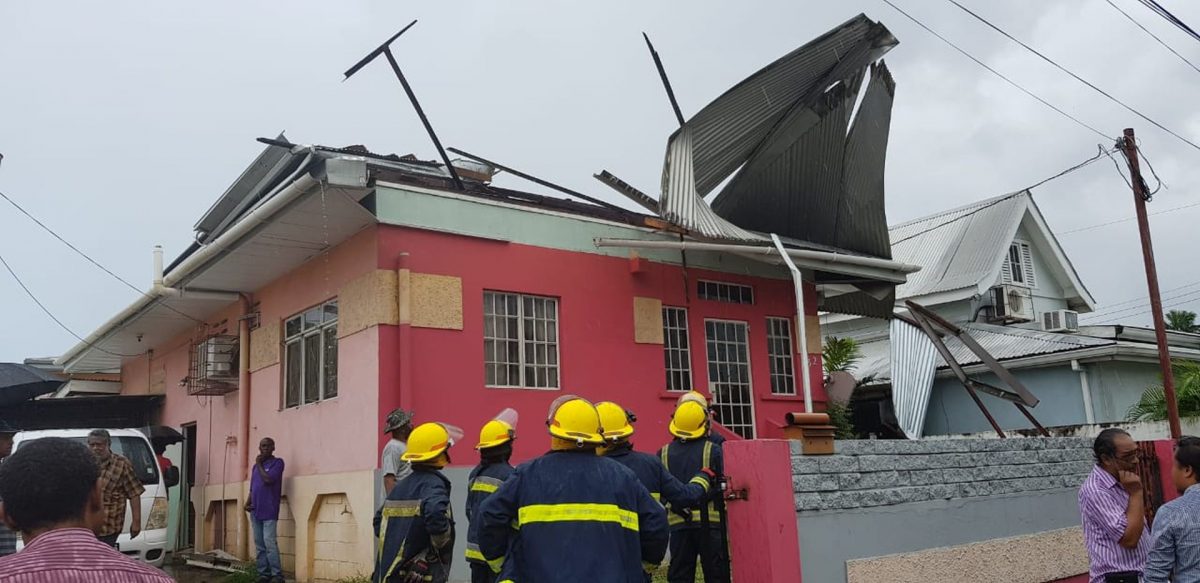 Fire officers at the scene of a building where the roof was damaged after heavy winds on Wrightson Road, yesterday