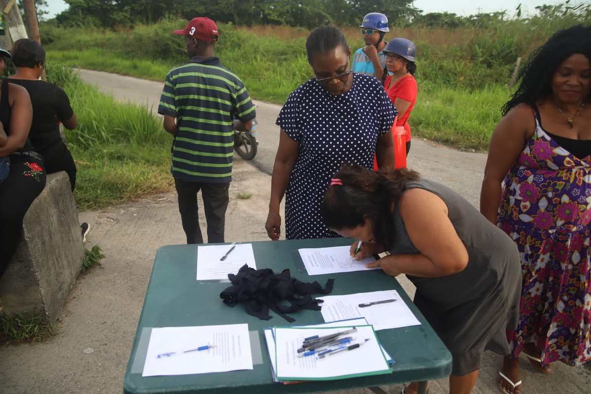 A resident of Friendship signing the ‘Never Again’ petition. (Terrence Thompson photo)