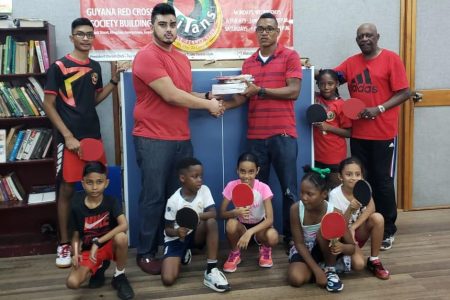 Proprietor of West Indian Sports Complex, Javed Khan (standing second from left) hands over the donation to founder of Titans Table Tennis club, Dwain Dick in the presence of members of the club
