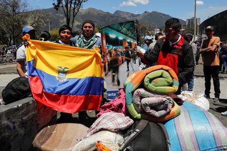 People hold an Ecuadorian flag as they participate in a cleanup of the streets in the aftermath of the last days’ protests, after the government of Ecuadorian President Lenin Moreno agreed to repeal a decree that ended fuel subsidies, in Quito, Ecuador October 14, 2019. REUTERS/Henry Romero