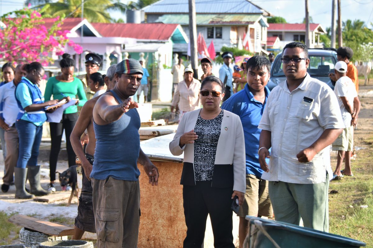 Minister of State, Dawn Hastings-Williams (centre) and Regional Information Officer, Ganesh Mahipaul (right), pay keen attention to Zeelugt North resident, Pragld Ramkissoon (left) as he points out damage caused by the flood. (Ministry of the Presidency photo)