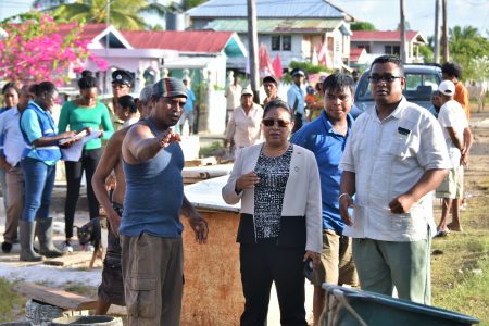 Minister of State, Dawn Hastings-Williams (centre) and Regional Information Officer, Ganesh Mahipaul (right), pay keen attention to Zeelugt North resident, Pragld Ramkissoon (left) as he points out damage caused by the flood. (Ministry of the Presidency photo)