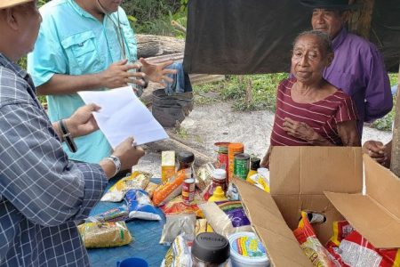 Minister Raphael Trotman (second from left) as they presented the groceries to Lucille Williams at Karisparu (right) (Natural Resources Ministry photo)