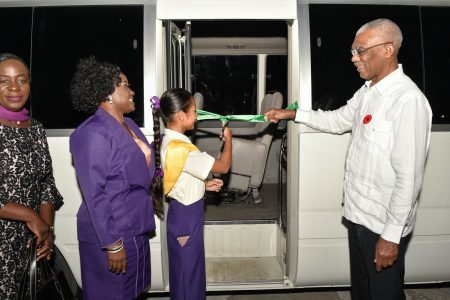 President David Granger is assisted by a President’s College student to cut the ceremonial ribbon to officially commission a school bus which will be used to transport students. Also pictured are Minister of Education, Dr Nicolette Henry (first, left) and Principal (Ag) Ms Samantha Success. (Ministry of the Presidency photo)