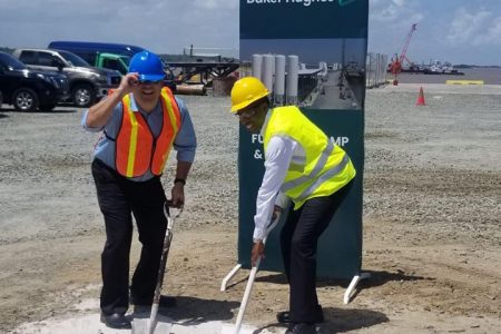 Philip Fernandes, CEO of John Fernandes Ltd (left) and  Uwem Ukpong, COO of Baker Hughes, breaking ground at the  GPort facility, which JFL states was “in support of the growing Oil Sector”. (Photo- JFL’s Facebook Page.) 