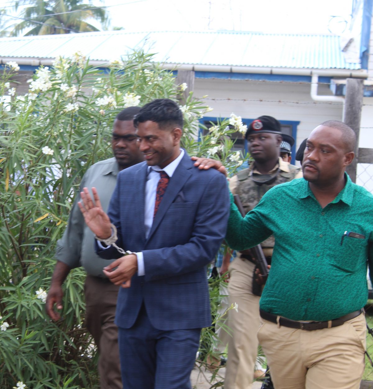 Marcus Brian Bisram [second from right) on his way to court this morning.