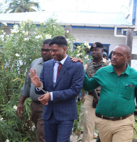 Marcus Brian Bisram (second from right) on his way to court in 2019