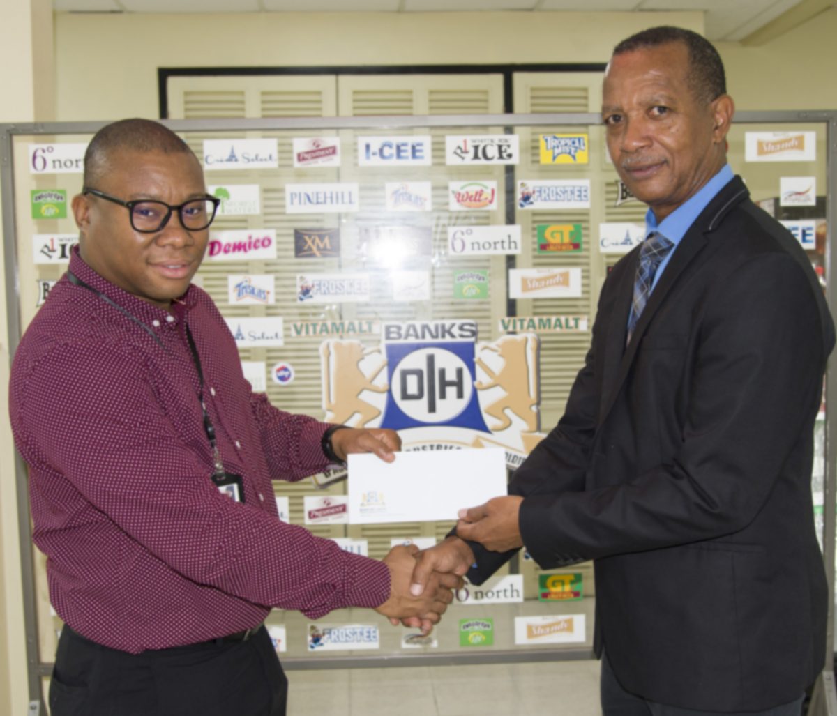 Brand Manager, Colin King (left) recently presented a sponsorships pact to President of the Athletic Association of Guyana (AAG), Aubrey Hutson on behalf of Banks DIH Limited.

